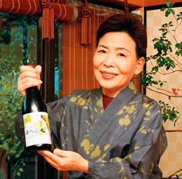山ぶどうワイン「小さな巨人」を手にする女将さん