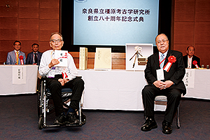 橿原考古学研究所創立80周年を祝う会より事業支援の目録が菅谷所長へ贈呈される