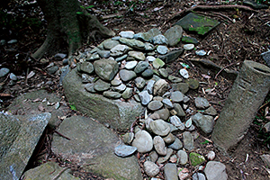 集落の南の山の中にある山口神社に置かれた御白石の石積み