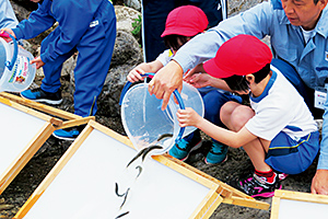 天川小学校の児童によるアユ稚魚の放流