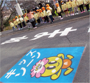 市キャラクター「みくちゃん」と「キッズゾーン」の文字が入った路面標示